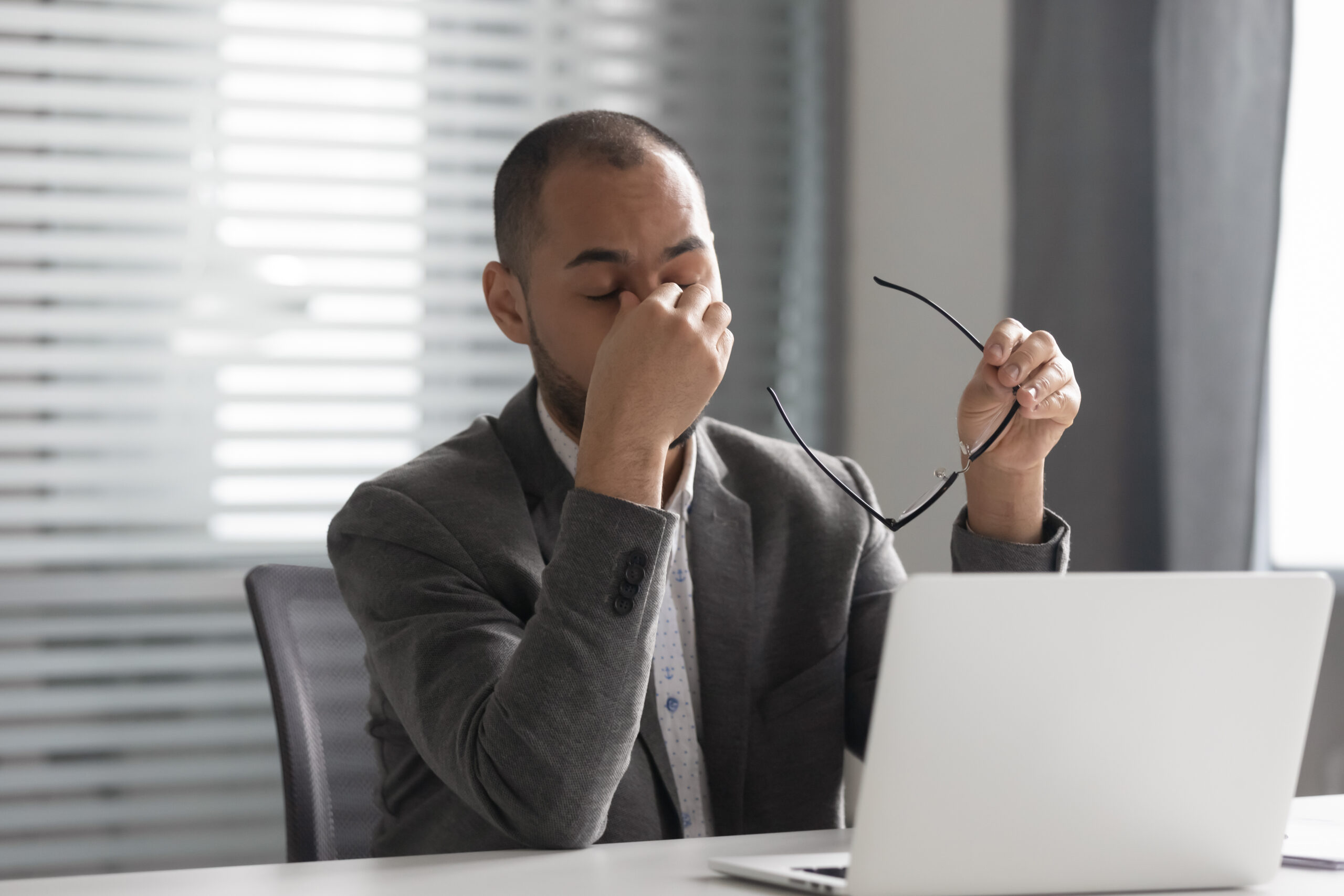 Business professional experiencing screen fatigue from excessive computer work