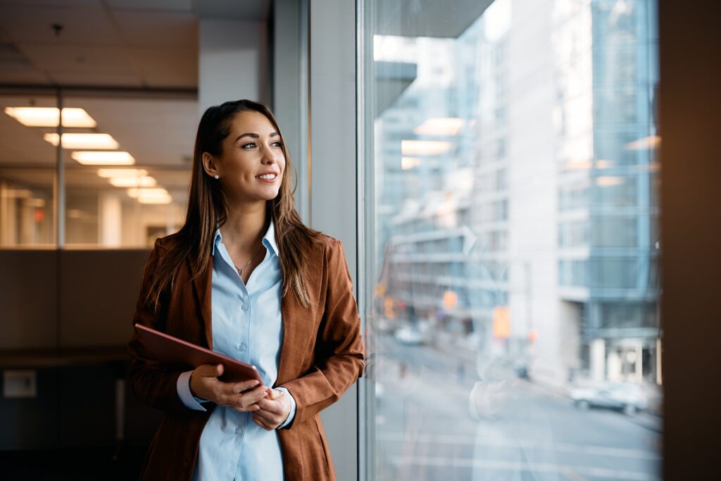 Young business professional looking optimistic and looking out the window